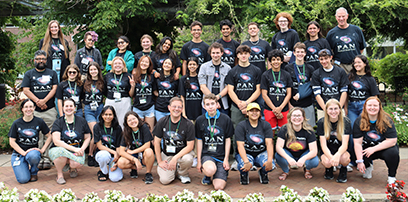 A group photo of the 30th annual Physics of Atomic Nuclei (PAN) students and program volunteers. They are wearing matching black PAN shirts. 