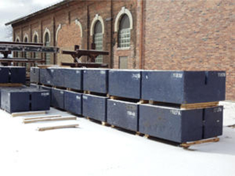Shielding blocks for FRIB construction are in a staging area, ready for delivery. Each recycled steel block weighs 10 tons.