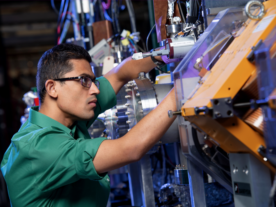 Man with green shirt and glasses working on machine