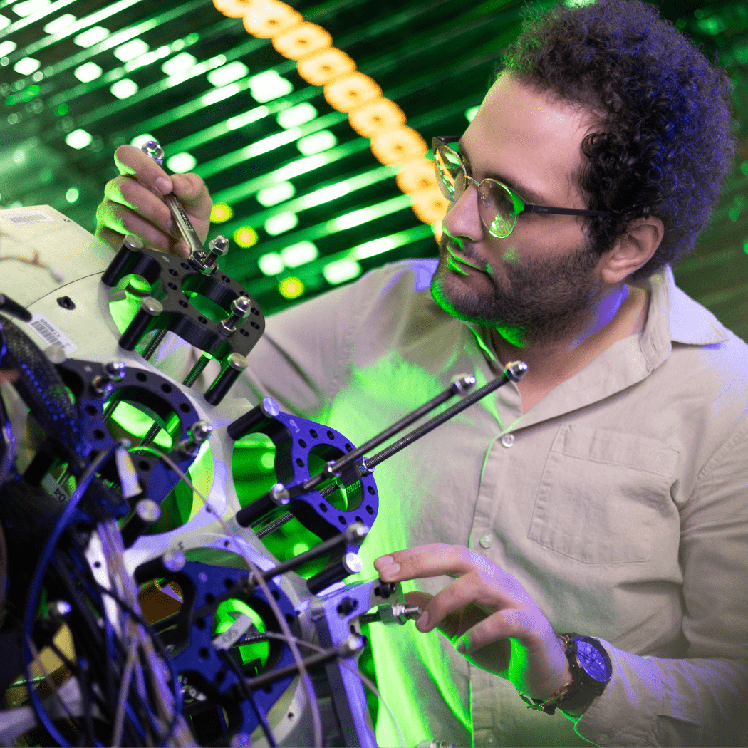 Man wearing glasses working machinery in lab