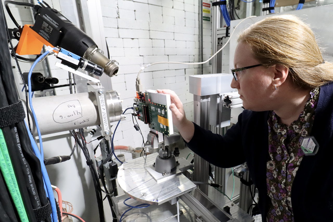 A photo of a woman working inside the KSEE vault at FRIB