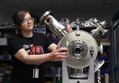 A graduate student adjusts beam instrumentation at the FRIB Laboratory.