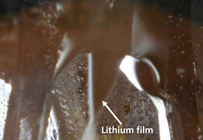 Melted liquid lithium film as seen from a view port in the charge stripper.