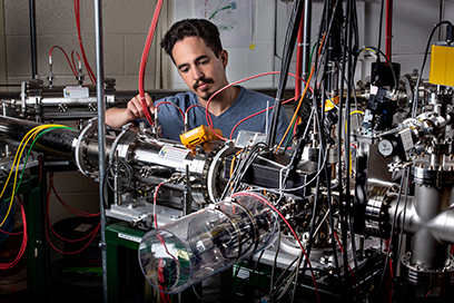 A graduate student works with an instrument at the FRIB Laboratory.