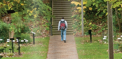 A student walks through one of the many gardens on campus.