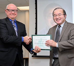 MSU College of Natural Science Dean Phil Duxbury (left) presents Jie Wei, professor of physics at FRIB and in the MSU Department of Physics and Astronomy and FRIB’s Accelerator Systems Division Director, (right) with his 2022 Outstanding Faculty Award. 