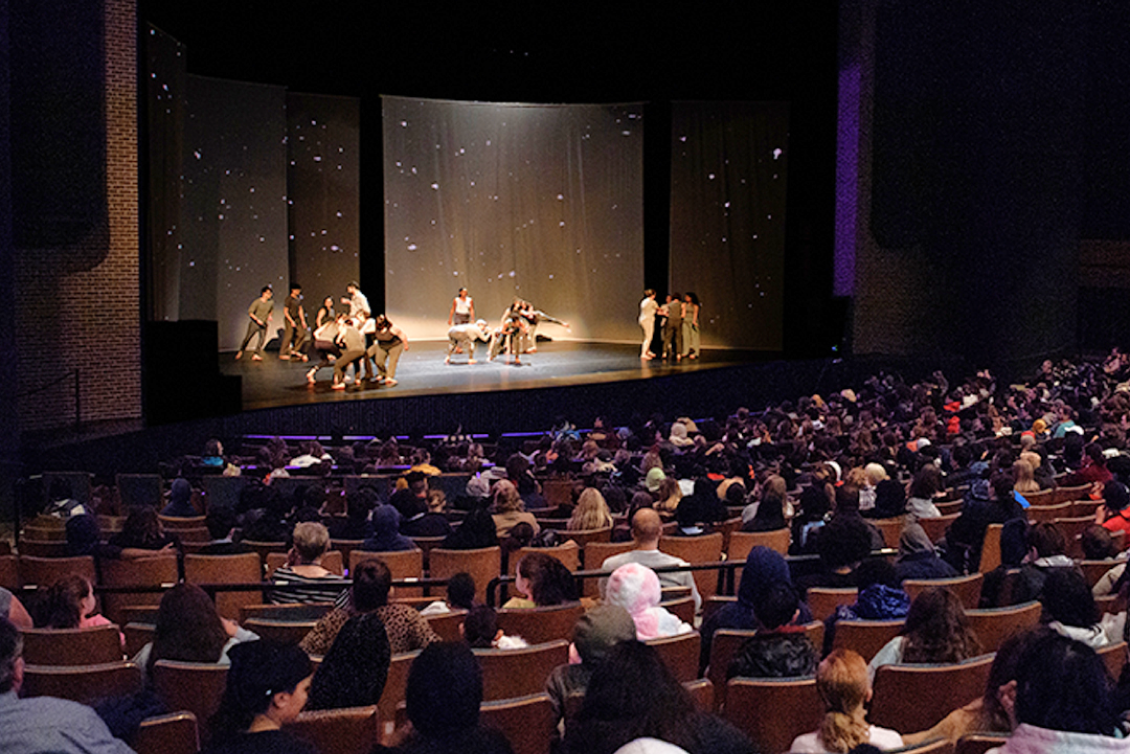 Auditorium filled with guests watching performers dance to "Isotopes in Motion"